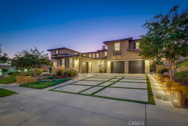 mediterranean / spanish house with driveway, a garage, a tiled roof, cooling unit, and stucco siding