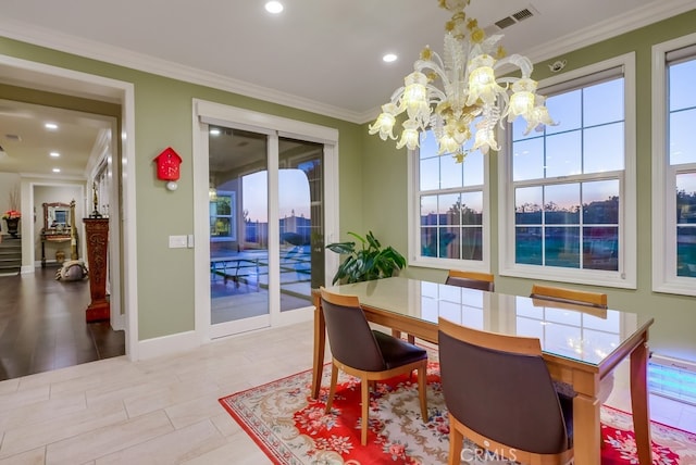 dining space with crown molding, a chandelier, and light wood-type flooring