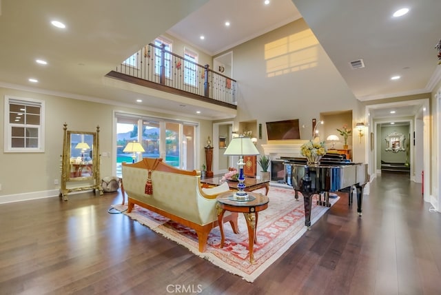 living room with ornamental molding, dark wood-type flooring, and a high ceiling