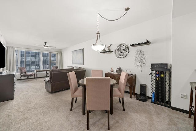 carpeted dining space with ceiling fan