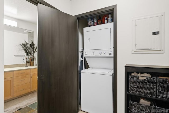 laundry room featuring stacked washer and dryer and electric panel