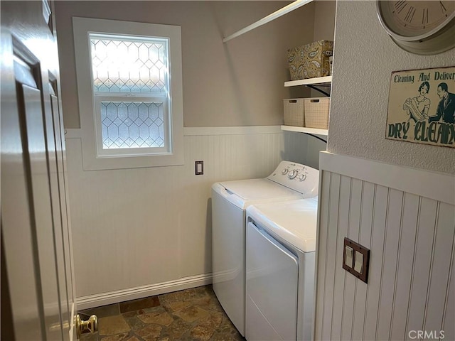 7 Corte Abertura, San Clemente, CA 92673 - laundry room featuring washing machine and clothes dryer, dark stone finish floors, and a wainscoted wall