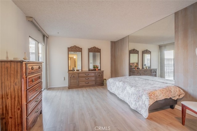 bedroom with a textured ceiling and light wood-type flooring