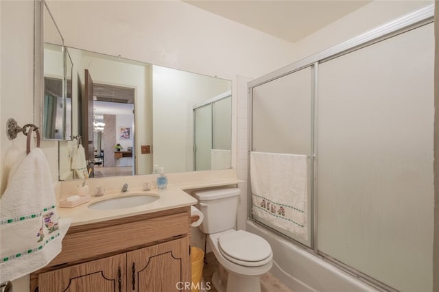 full bathroom featuring combined bath / shower with glass door, vanity, and toilet