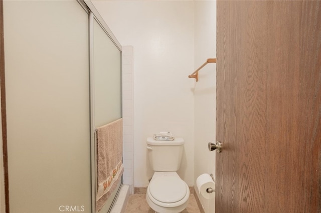 bathroom with tile patterned flooring, toilet, and an enclosed shower