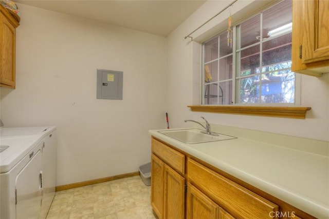 laundry room featuring cabinet space, washing machine and clothes dryer, electric panel, a sink, and baseboards