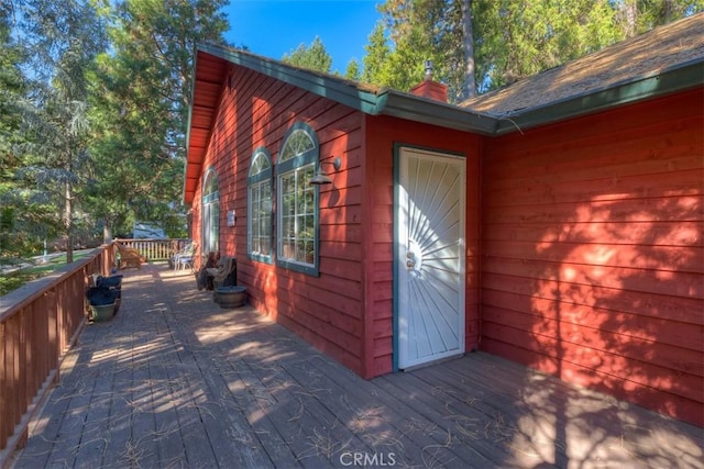 view of side of property featuring a deck and a chimney