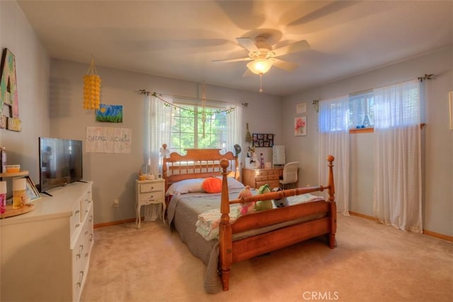 bedroom with ceiling fan, light colored carpet, and baseboards