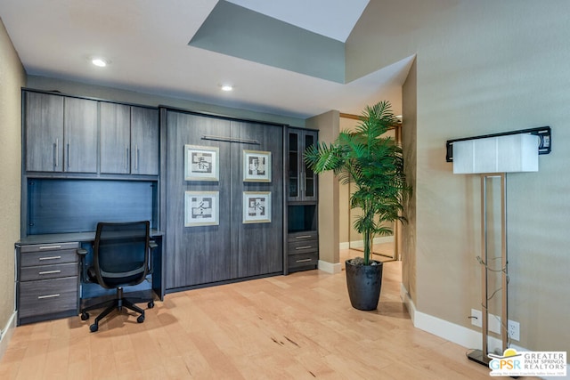 home office featuring built in desk and light hardwood / wood-style floors