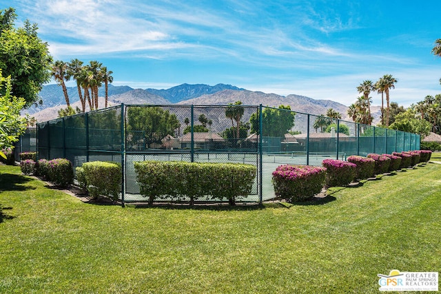 view of sport court featuring a mountain view and a lawn