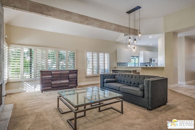 living room featuring light carpet, beamed ceiling, and a wealth of natural light