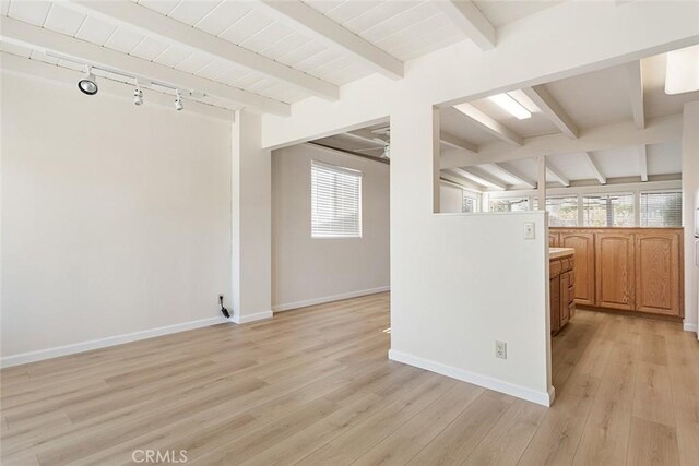 interior space featuring a healthy amount of sunlight, beamed ceiling, and light wood-type flooring