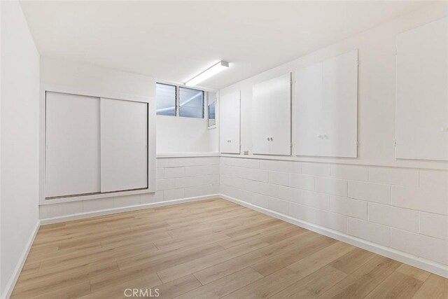 basement with light hardwood / wood-style flooring