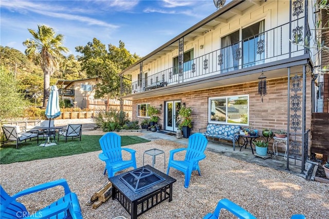 view of patio featuring a fire pit and a balcony