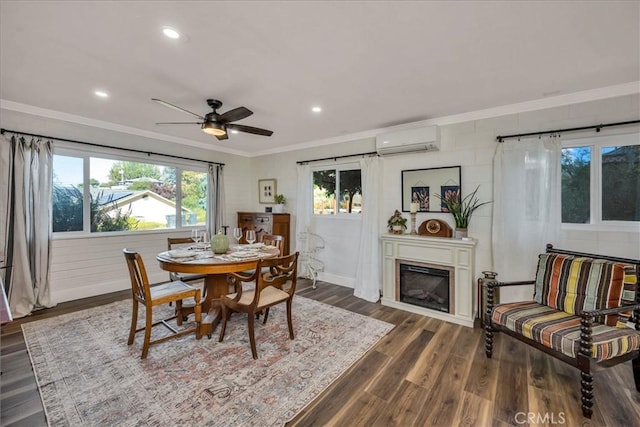 dining room featuring ornamental molding, dark wood-type flooring, a wall mounted air conditioner, and a wealth of natural light