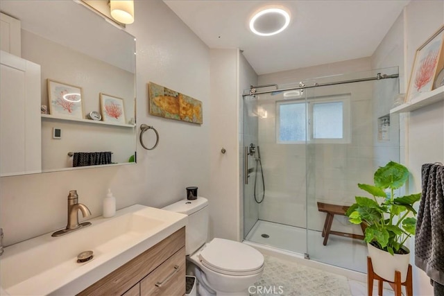 bathroom featuring vanity, toilet, and a shower with shower door