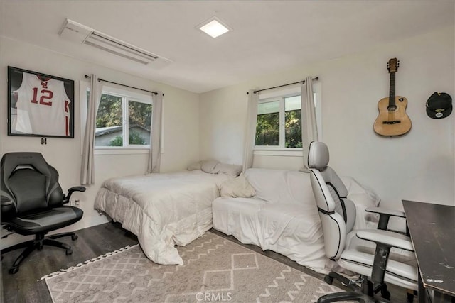 bedroom with hardwood / wood-style floors and multiple windows