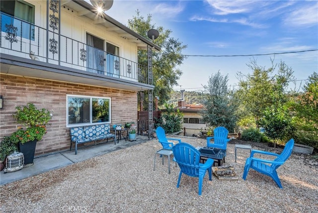 view of patio / terrace with an outdoor fire pit and a balcony