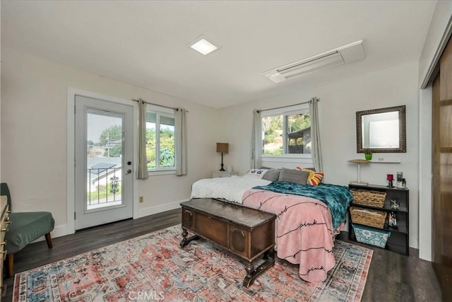 bedroom with access to outside and dark hardwood / wood-style floors