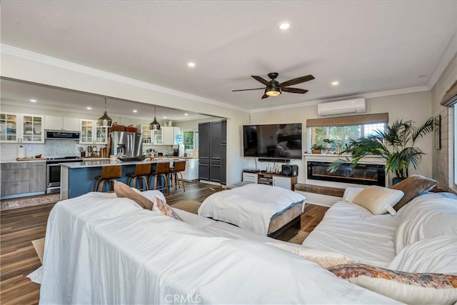 living room featuring dark hardwood / wood-style floors, ceiling fan, a wall unit AC, and ornamental molding