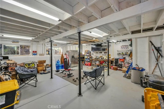 basement with a workshop area and stainless steel fridge with ice dispenser