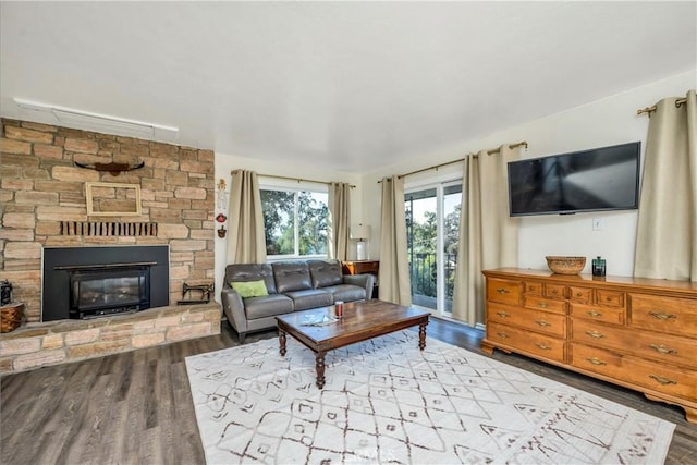 living room with light wood-type flooring and a stone fireplace