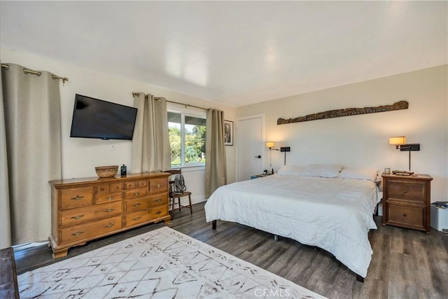 bedroom with dark hardwood / wood-style flooring