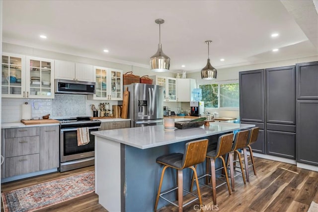 kitchen featuring gray cabinets, pendant lighting, a large island, stainless steel appliances, and white cabinets