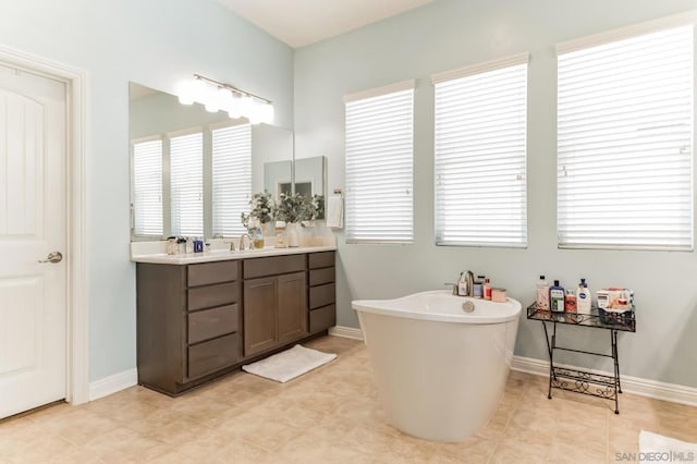 bathroom featuring a wealth of natural light, vanity, and a washtub