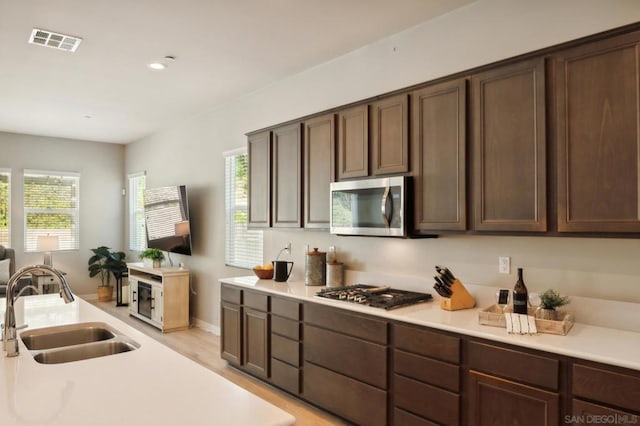 kitchen featuring dark brown cabinetry, appliances with stainless steel finishes, and sink