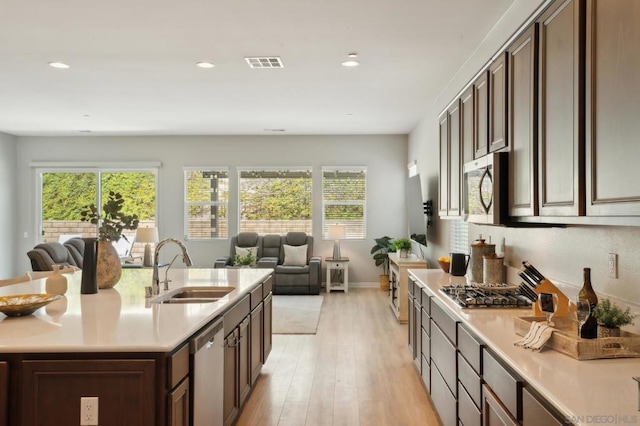 kitchen featuring sink, light hardwood / wood-style flooring, dark brown cabinets, and stainless steel appliances