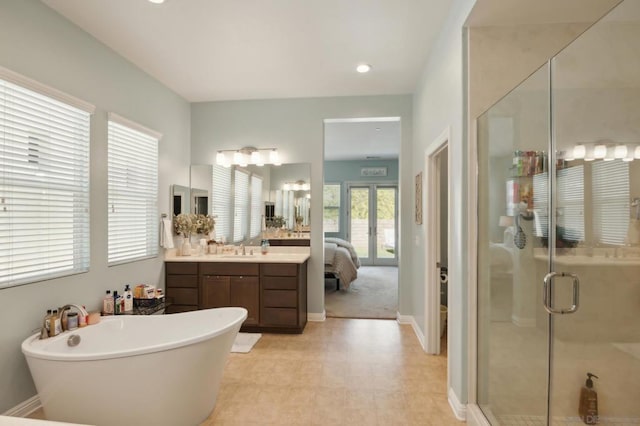 bathroom with vanity, french doors, and separate shower and tub