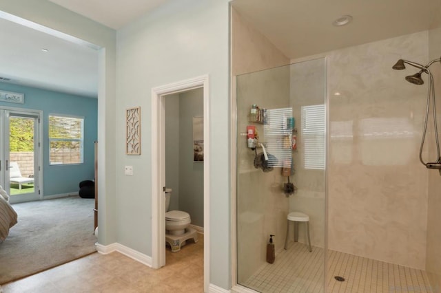 bathroom with a shower with door and toilet