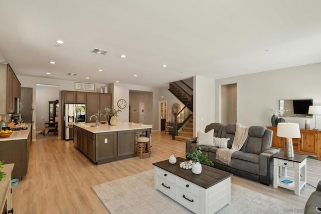 living room with light hardwood / wood-style floors and sink