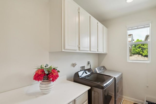 washroom with cabinets and washer and clothes dryer