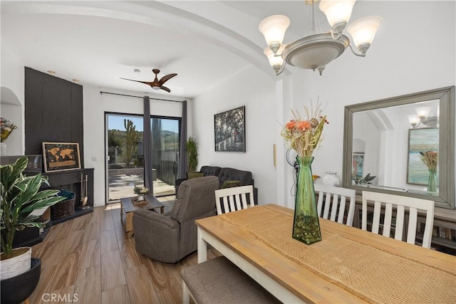 dining area featuring hardwood / wood-style flooring and ceiling fan with notable chandelier