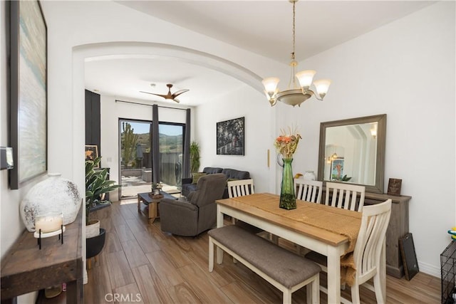 dining space featuring hardwood / wood-style floors and ceiling fan with notable chandelier