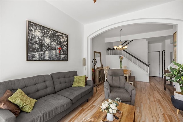 living room featuring a chandelier and light wood-type flooring