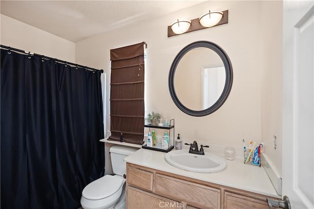 bathroom with a textured ceiling, vanity, and toilet