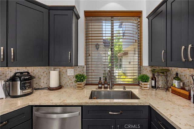 kitchen with backsplash, dishwasher, light stone counters, and sink