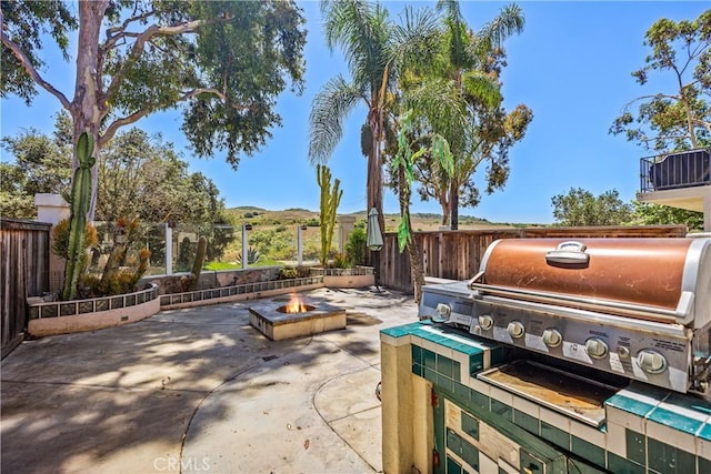 view of patio featuring area for grilling, a mountain view, and an outdoor fire pit