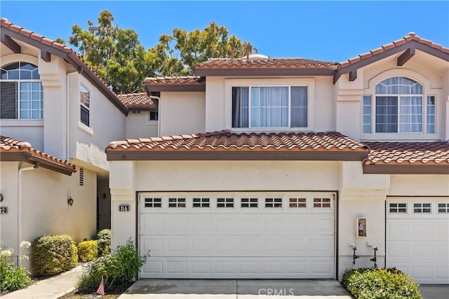 mediterranean / spanish home featuring a garage