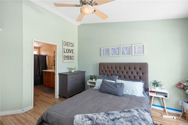 bedroom with ceiling fan, light hardwood / wood-style floors, lofted ceiling, and ensuite bathroom