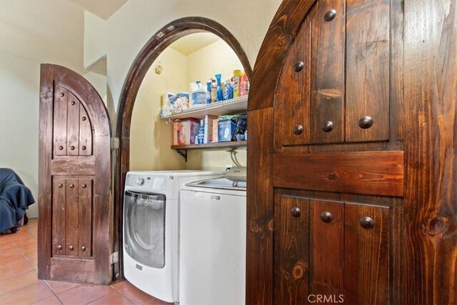 laundry room featuring washing machine and clothes dryer and light tile patterned floors