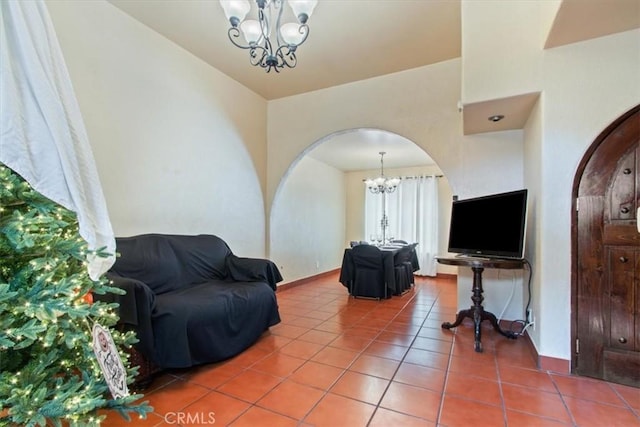 living room with tile patterned floors, vaulted ceiling, and an inviting chandelier