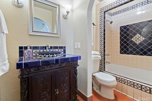 full bathroom featuring tile patterned flooring, vanity, toilet, and tiled shower / bath