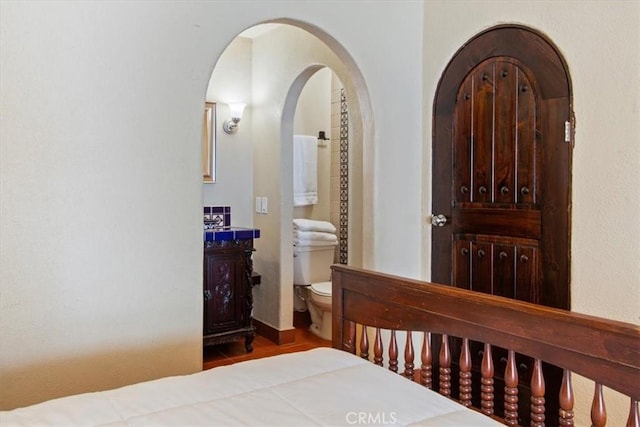 interior space with hardwood / wood-style floors and ensuite bathroom