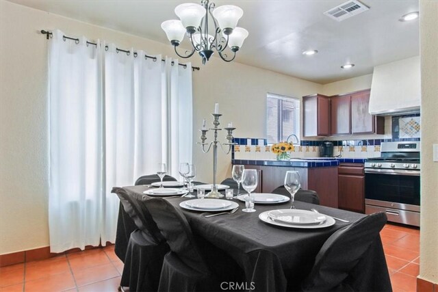 dining room with light tile patterned flooring and an inviting chandelier