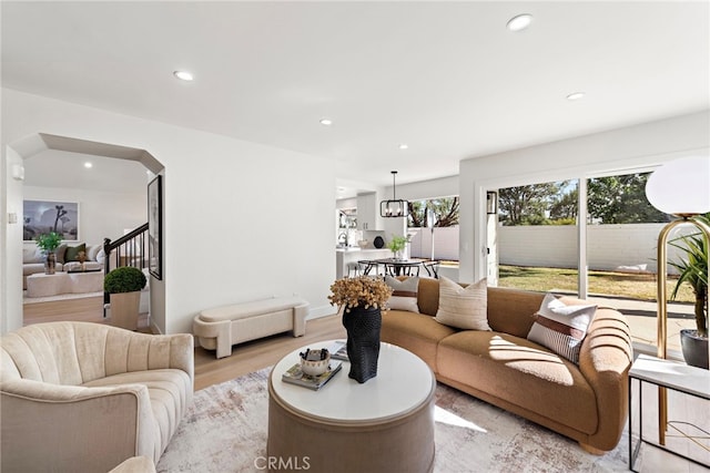 living room with light hardwood / wood-style floors and a notable chandelier