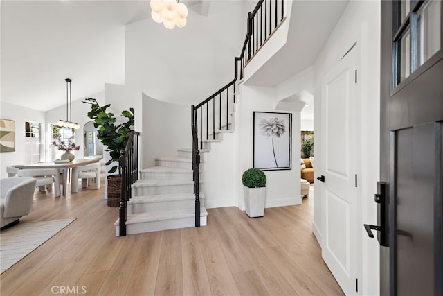 foyer entrance featuring an inviting chandelier, light wood-type flooring, and plenty of natural light